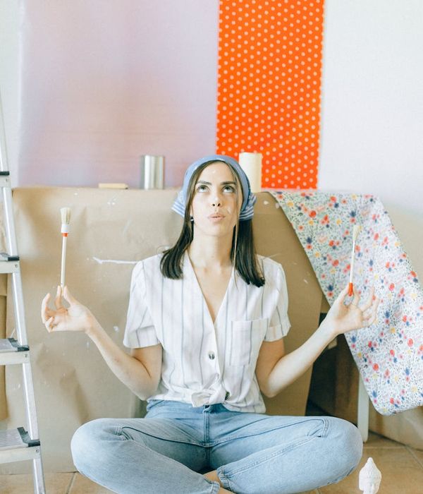 Woman in a peaceful yoga pose against a soft white background.